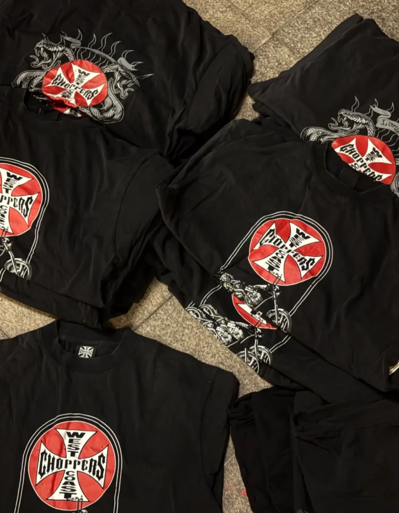 Black T-shirts laid out with red and white graphics, motorcycles and dragons
