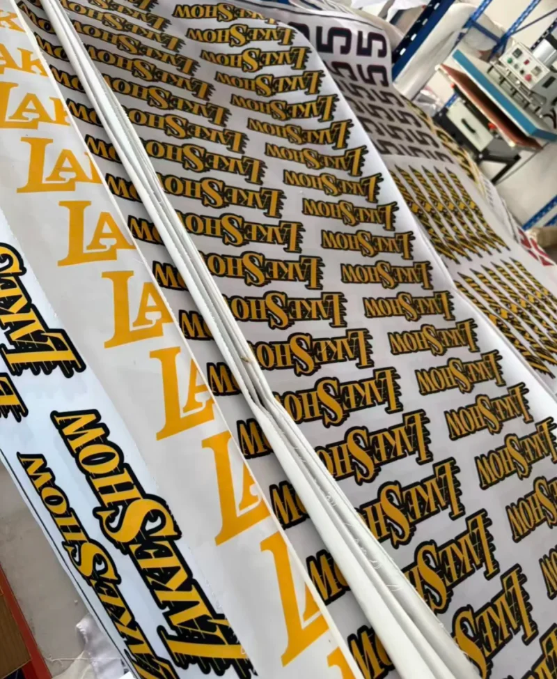 Sheets with repeated yellow and black letters, words and shapes beside workshop equipment.