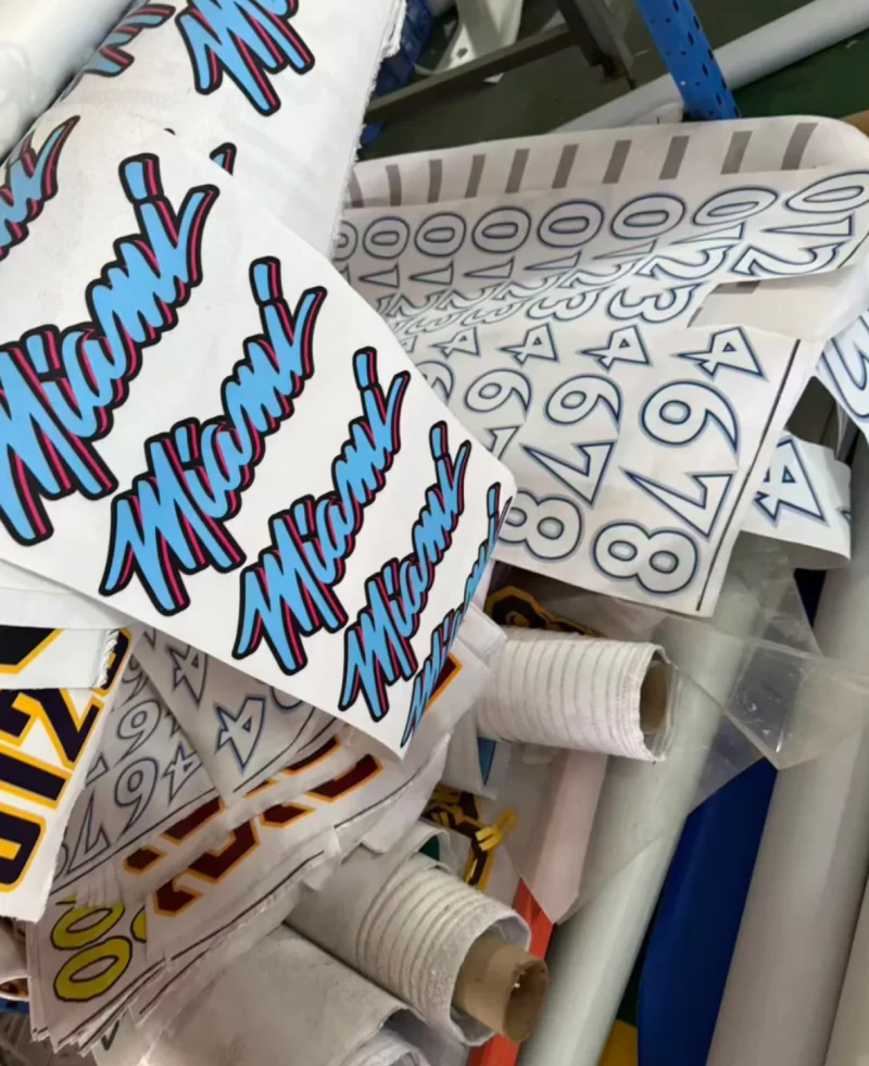 White rolls carrying repeated turquoise and pink lettering beside outlined numbers