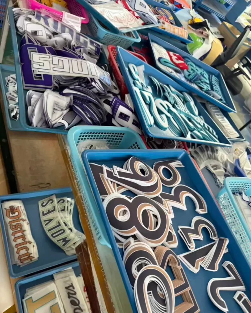 Blue trays holding brown, turquoise and purple numbers and lettering components