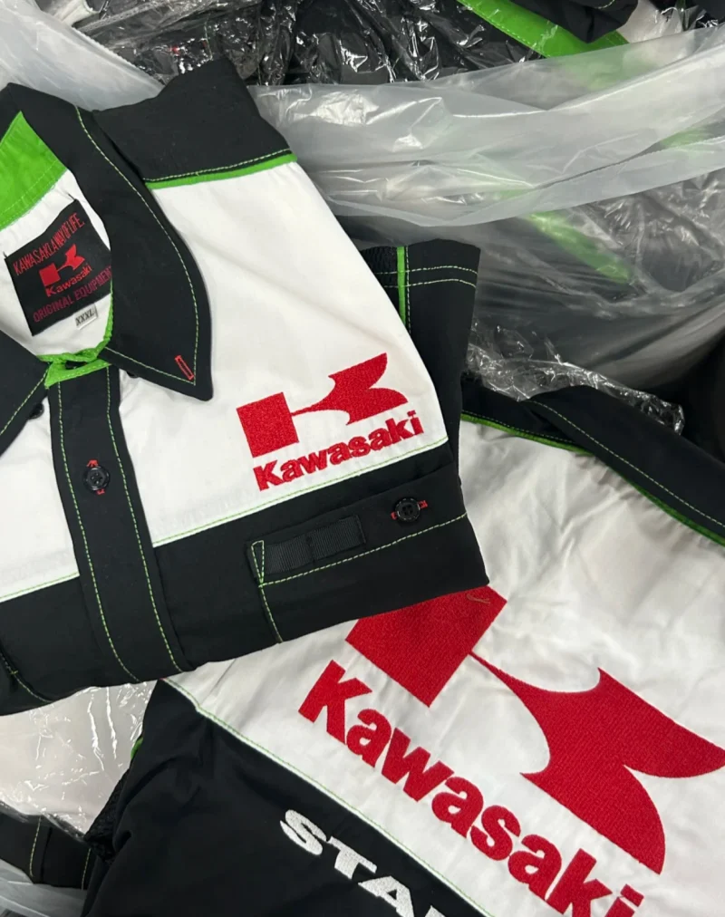 Black, white and green shirt with a contrasting collar, green stitching and a red emblem