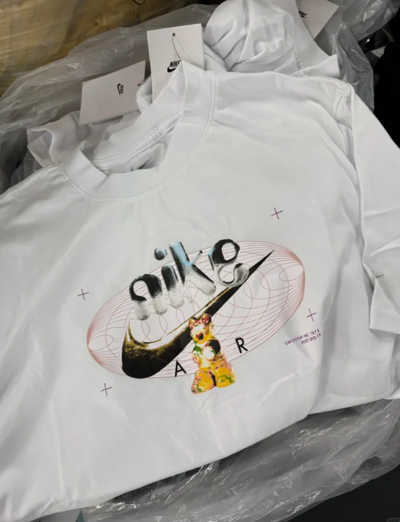 Folded white T-shirt with lettering and a multicoloured chest illustration