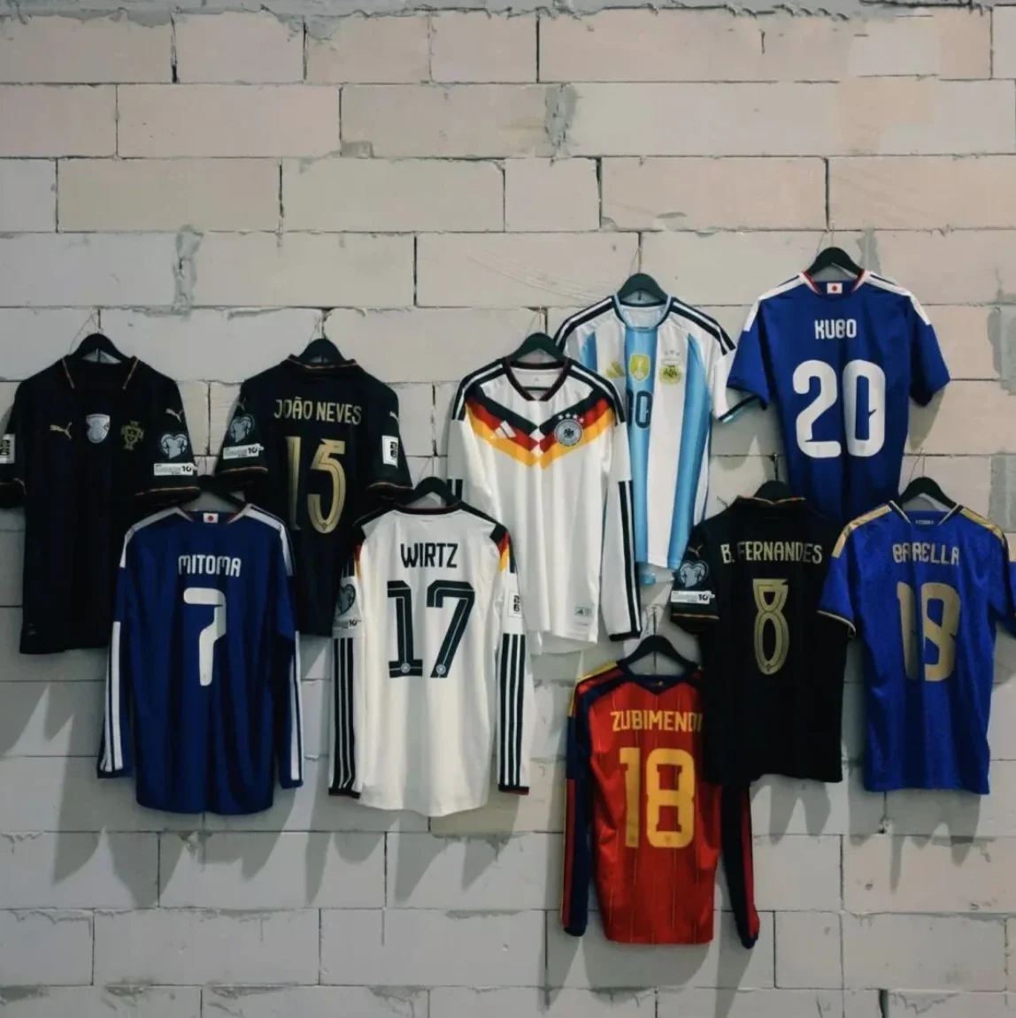 Jerseys in different colours hanging on a wall.